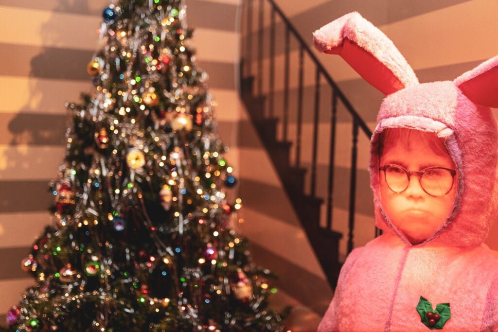 Pink bunny suit figure beside a Christmas tree at ChristmasLand