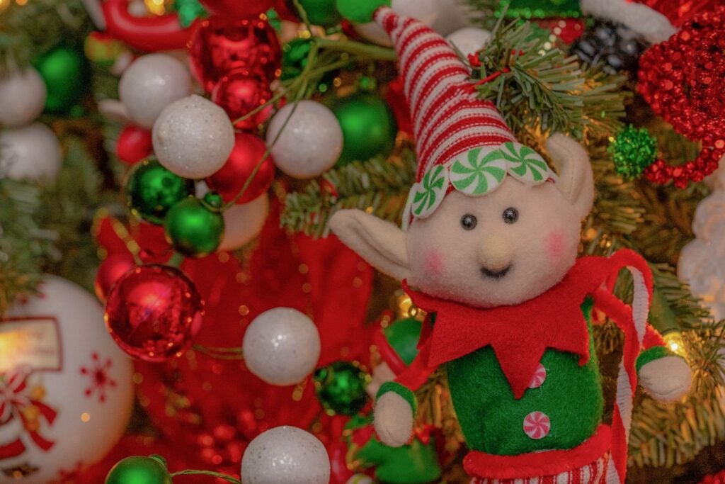 Green elf ornament among red and white baubles