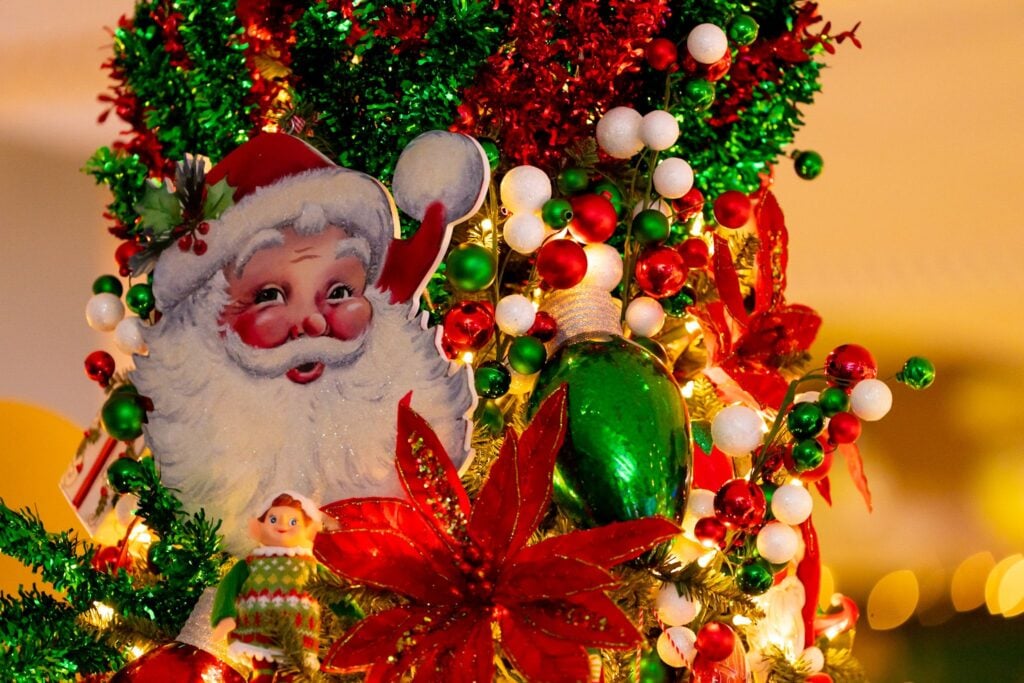 Santa ornament among red and gold Christmas decorations